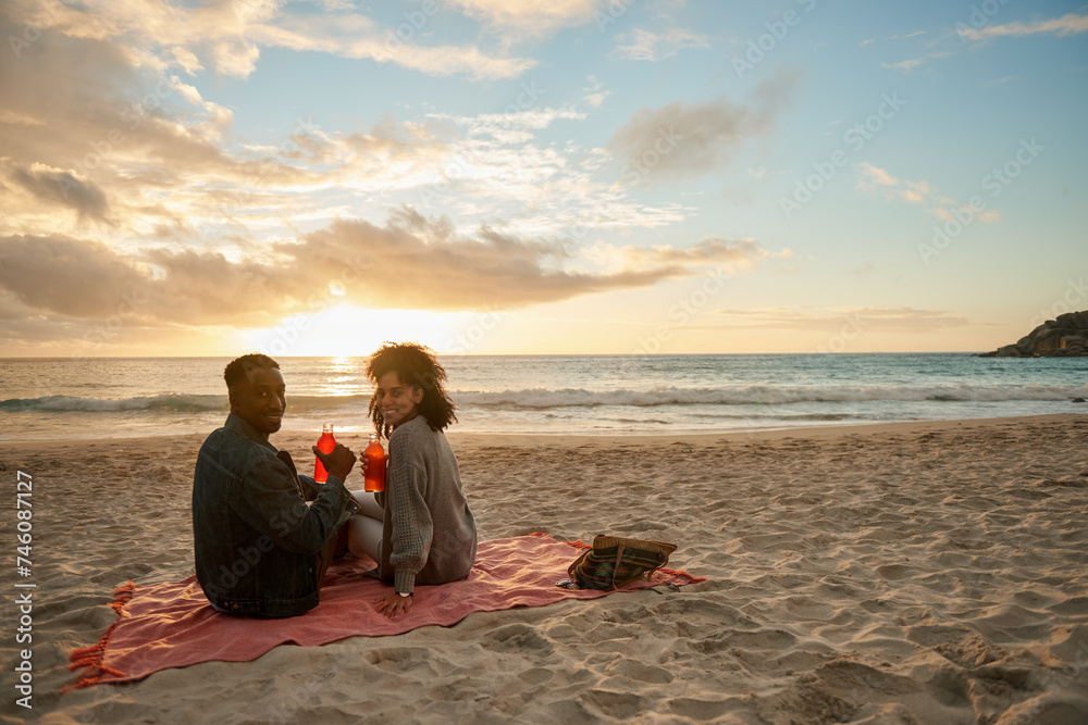 Smiling young multiethnic couple enjoying a sunset at the beach