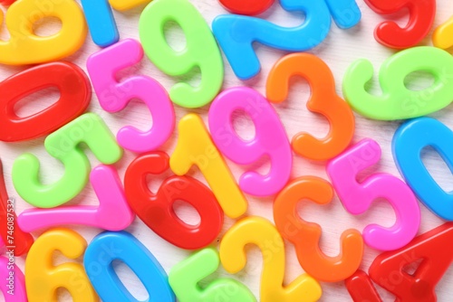 Colorful numbers on white wooden school desk, top view