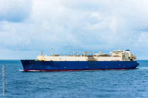 Tanker ship, sailing through calm, blue ocean. She is transporting cargo on her international trade route. 