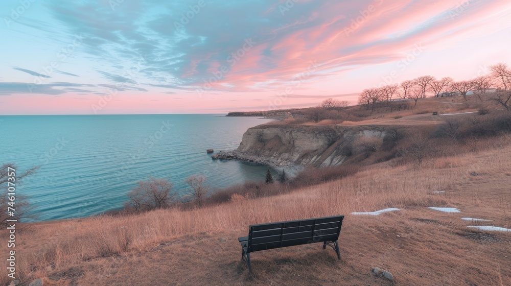 a bench sitting on the side of a cliff overlooking a body of water with a cliff in the middle of it.