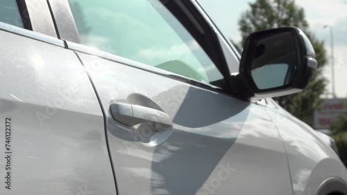A passenger woman opens the door and gets in to the car cab, Close up.