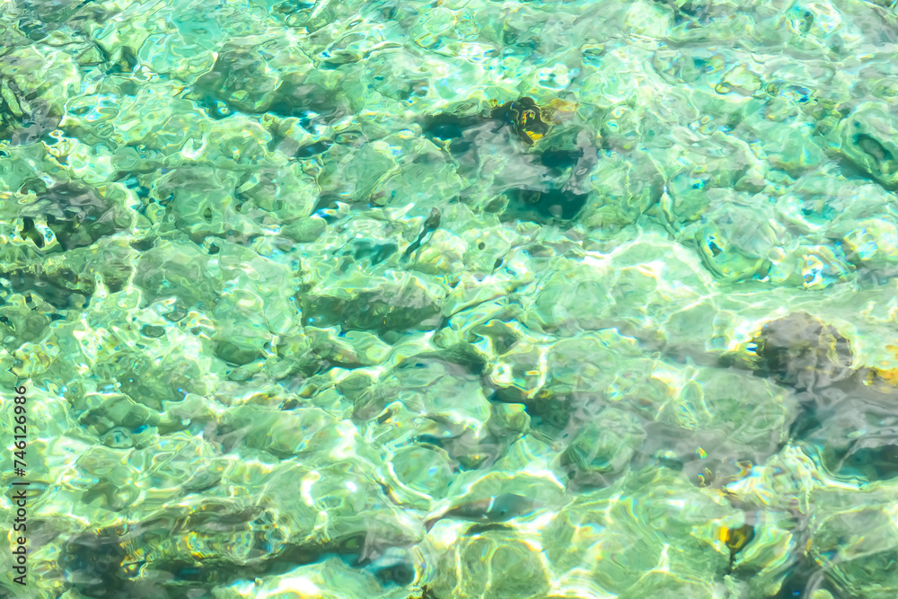 Turquoise blue water of Caribbean sea clear view on stones and rocks..	