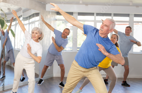 Enthusiastic elderly man attending group choreography class, learning modern dynamic dances. Concept of active lifestyle of older generation ..
