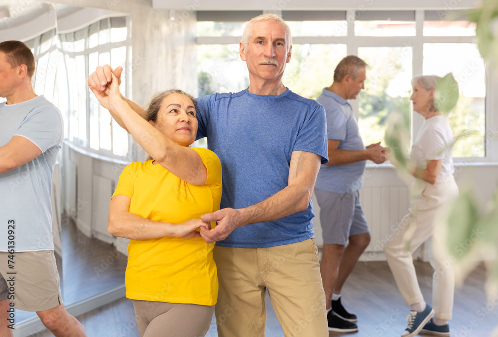 Fototapeta premium Elderly man and elderly woman dance ballroom dance waltz in studio