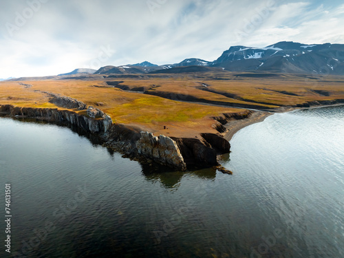 drone shot of an iceberg in Svalbard, a large piece of iceberg on the water in the middle of wild and frozen nature, usable for magazines and magazines, travel to arctic countries
