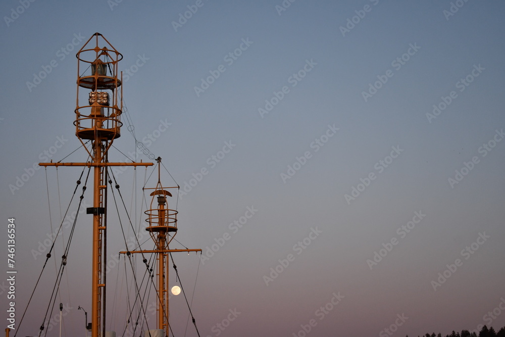 Lightship beacons at dusk with full moon