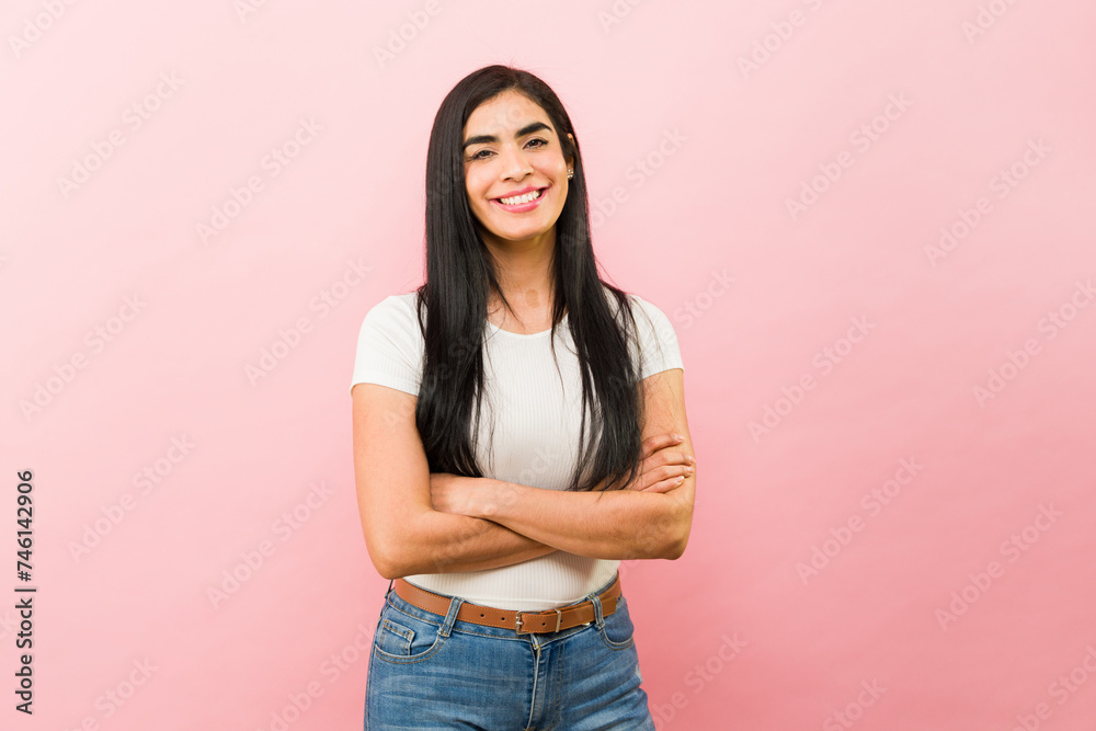 Attractive woman looking happy and smiling in a pink background Attractive woman looking happy and smiling in a pink background