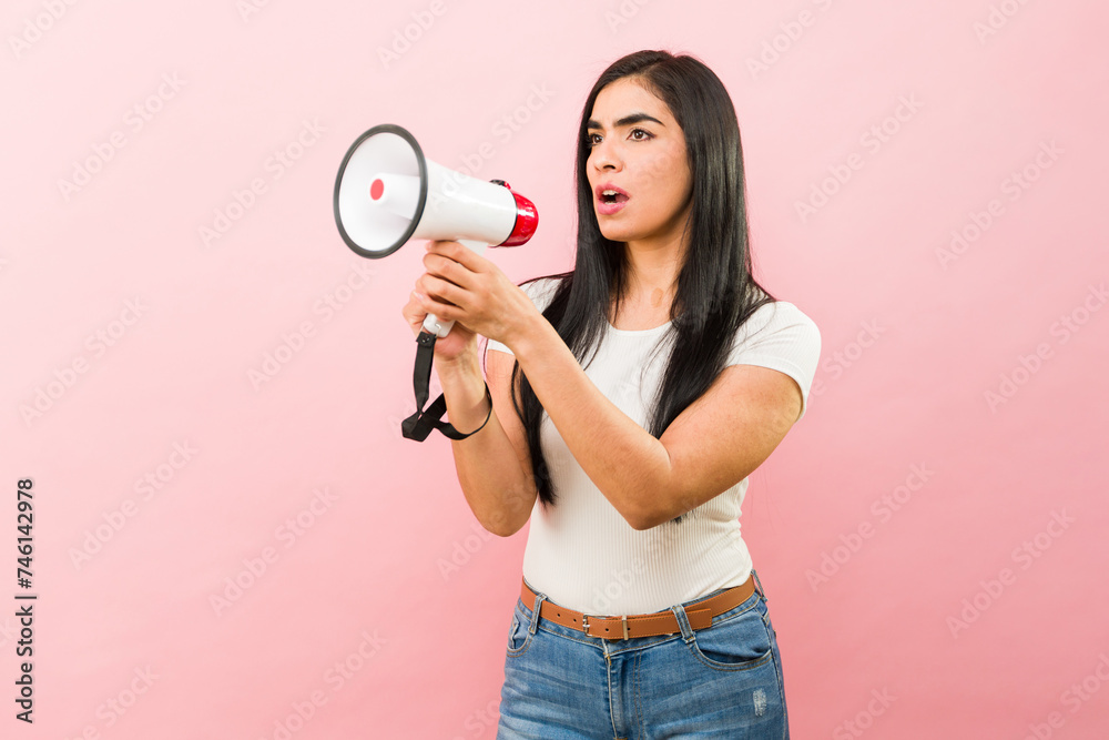 Angry latin woman screaming with a megaphone Angry latin woman screaming with a megaphone