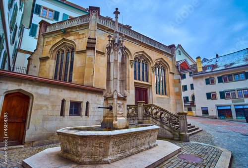 The old fountain on Zwingliplatz next to Grossmunsterkapelle, Zurich, Switzerland photo