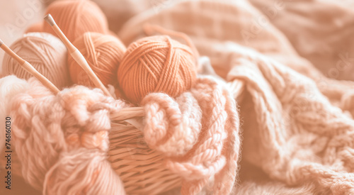 Colorful yarn balls and knitting needles in a basket, indicating a cozy crafting theme.