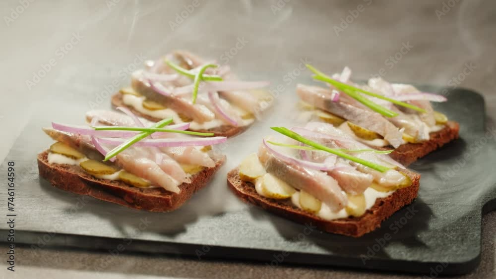Scandinavian sandwich smorrebroad with herring, onion, pickles on wooden desk close-up, holland Amsterdam cafe. Traditional hollandian fish sandwich Open Faced Scandinavian sandwich smorrebroad with herring, onion, pickles on wooden desk close-up, holland Amsterdam cafe. Traditional hollandian fish sandwich Open Faced