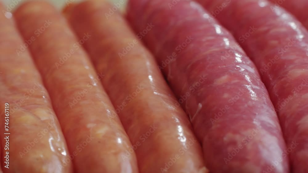 Raw sausage on plate close-up.Cooking hot dogs in boiling oil. Traditional asian corndog snacks street food. Korean Chinese street local market with traditional food. American fast food corndogs Raw sausage on plate close-up.Cooking hot dogs in boiling oil. Traditional asian corndog snacks street food. Korean Chinese street local market with traditional food. American fast food corndogs