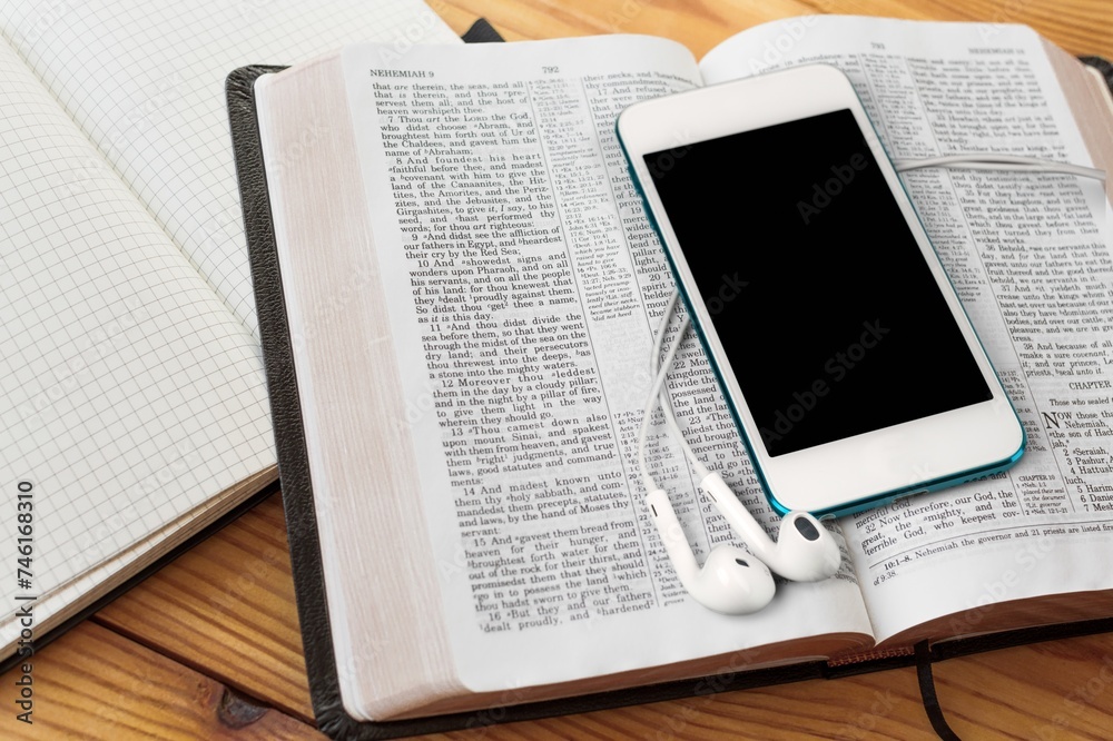 Obraz premium Christian online concept. Earphones, holy bible and smartphone.