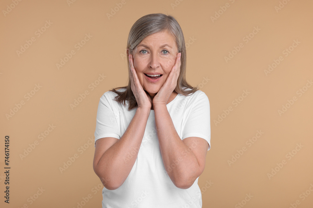 Portrait of surprised senior woman on beige background Portrait of surprised senior woman on beige background