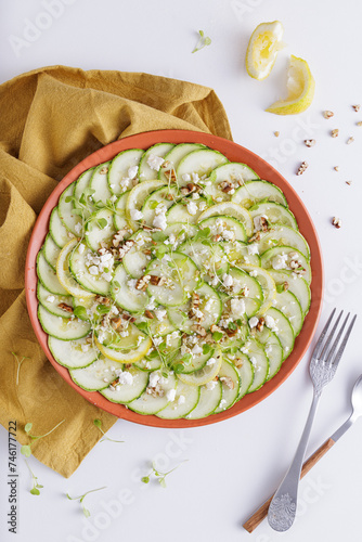 Cucumber Salad with White Cheese and Nuts Ingredients on a wooden chopping board and white background