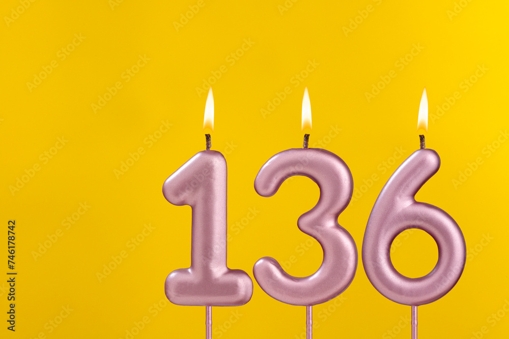 Birthday candle number 136 - Birthday celebration on yellow background Birthday candle number 136 - Birthday celebration on yellow background