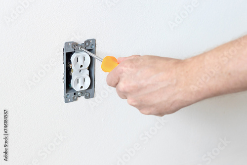 Installing electrical outlet. Attaching outlet receptacle to electrical box