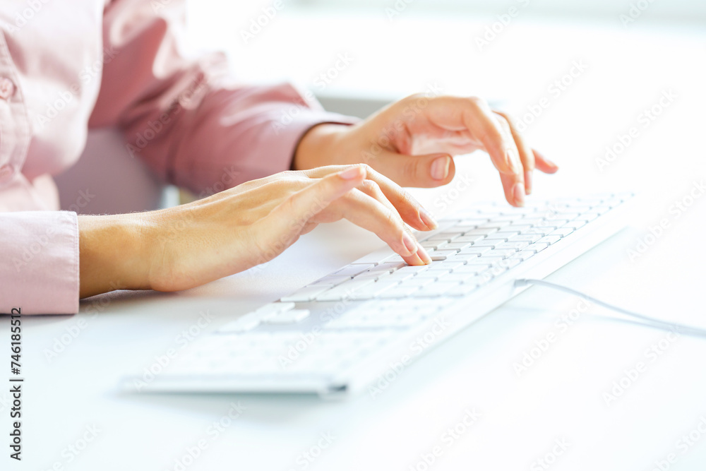 Woman office worker typing on the keyboard