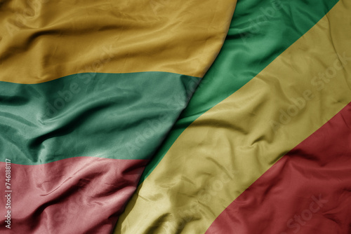 big waving national colorful flag of republic of the congo and national flag of lithuania .