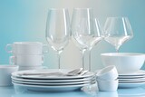 Set of many clean dishware, cutlery and glasses on light blue table