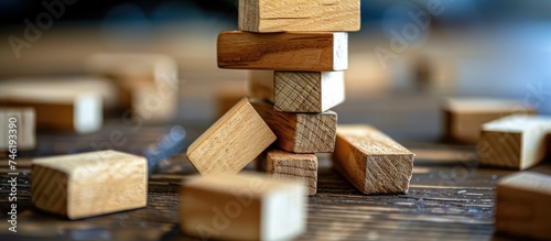 A stack of wooden blocks is neatly arranged on top of a sturdy table. The wooden blocks are of various sizes and shapes, creating an interesting visual display. photo