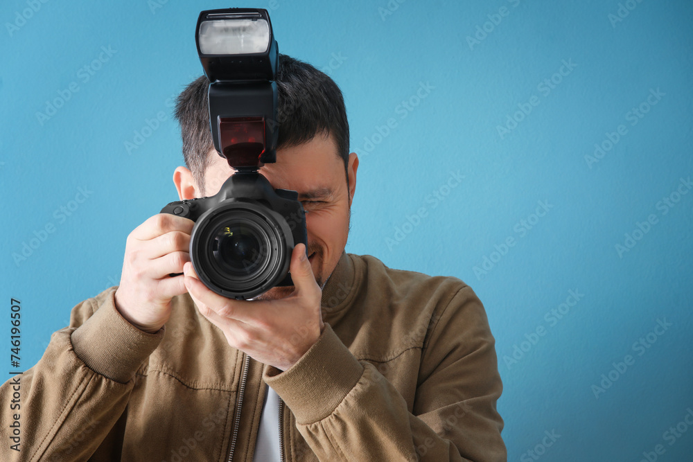 Male photographer with professional camera on blue background Male photographer with professional camera on blue background