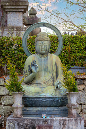 A seated bronze Buddha statue at Kurodani temle in Kyoto, japan photo