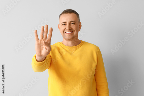Mature man showing four fin...
