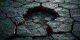 A hole in the ground with visible cracks on the surface.