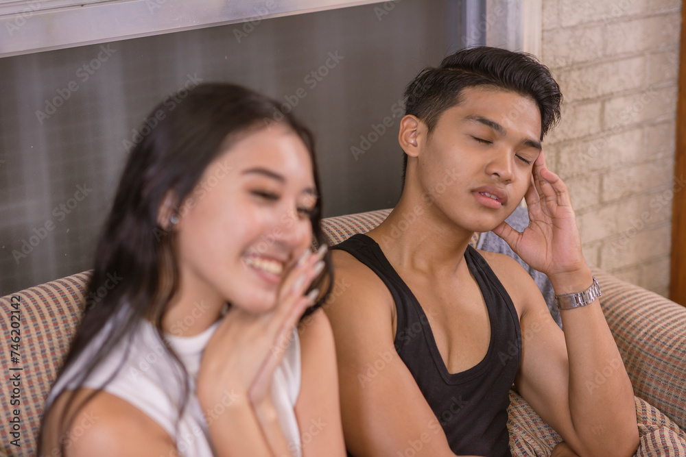 A young man falls asleep during the middle of his girlfriend talking about herself and plans. Depicting boredom and lack of interest in the conversation. A young man falls asleep during the middle of his girlfriend talking about herself and plans. Depicting boredom and lack of interest in the conversation.
