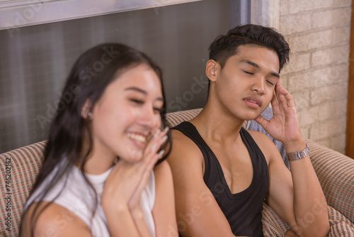 A young man falls asleep during the middle of his girlfriend talking about herself and plans. Depicting boredom and lack of interest in the conversation.