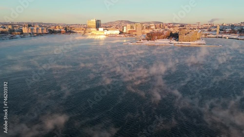 Golden Hour View Over Bjorvika In Sentrum borough of Oslo, Norway With Fog Floating Over Water. Aerial Push Forward  photo