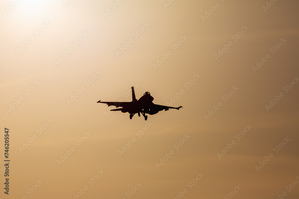 夕日を浴びて映画のような着陸するF-2戦闘機のシルエット