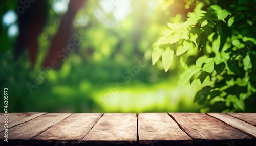 Empty rustic wooden table with defocused green lush foliage in the background