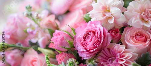 A collection of pink flowers arranged in a vase, showcasing traditional bridal bouquet colors and shapes. The delicate blooms add a touch of elegance and beauty to the room.