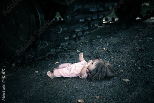 concept of destroying childhood by war. a frightened doll and tank. the concept of suffering of children and civilians in war. tank ran over a toy doll.