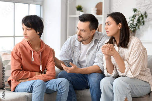 Fotografía Upset teenage boy with his parents sitting at home