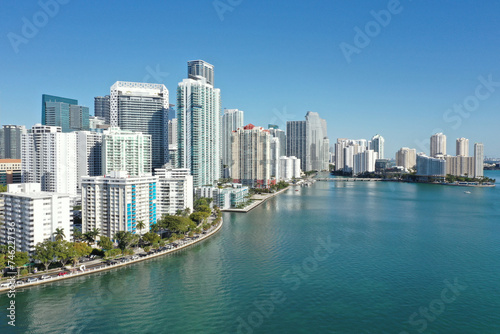 Aerial image of waterfront residential buildings in Brickell neighborhood of Miami, Florida reflected in calm water of Biscayne Bay on sunny morning. © Francisco