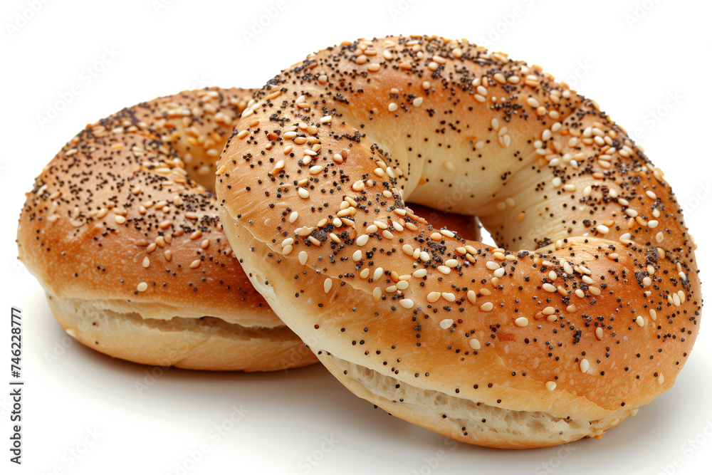 Two freshly baked bagels, generously sprinkled with a variety of seeds, against a white background