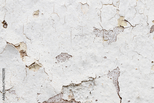 White paint peeling of the surface of a plaster wall, grunge background or texture