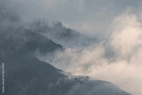 Mountain peaks in the clouds, foggy morning 