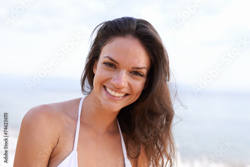 Beach, nature and portrait of woman for travel, vacation or adventure on tropical island. Happy, smile and young female person with positive and confident attitude by ocean on summer weekend trip.