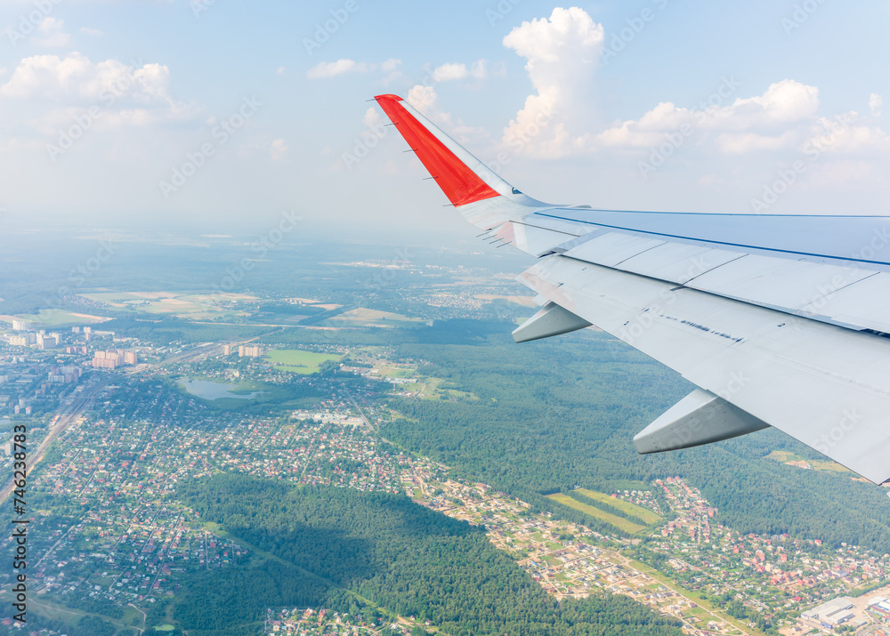 Fototapeta premium View from the airplane window during taking off on a clear summer morning