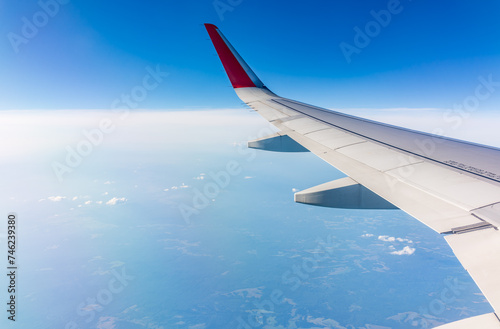 View from the airplane window at a beautiful cloudy sky and the airplane wing