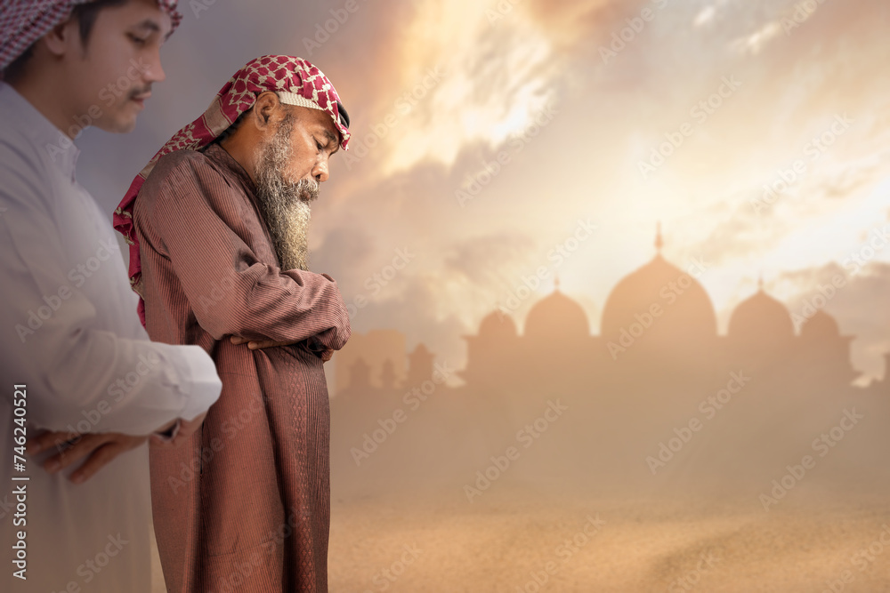 Two Muslim men with agal in a praying position (salat)