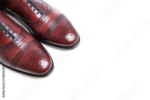 A pair of oxblood leather mens dress shoes on white with copy space