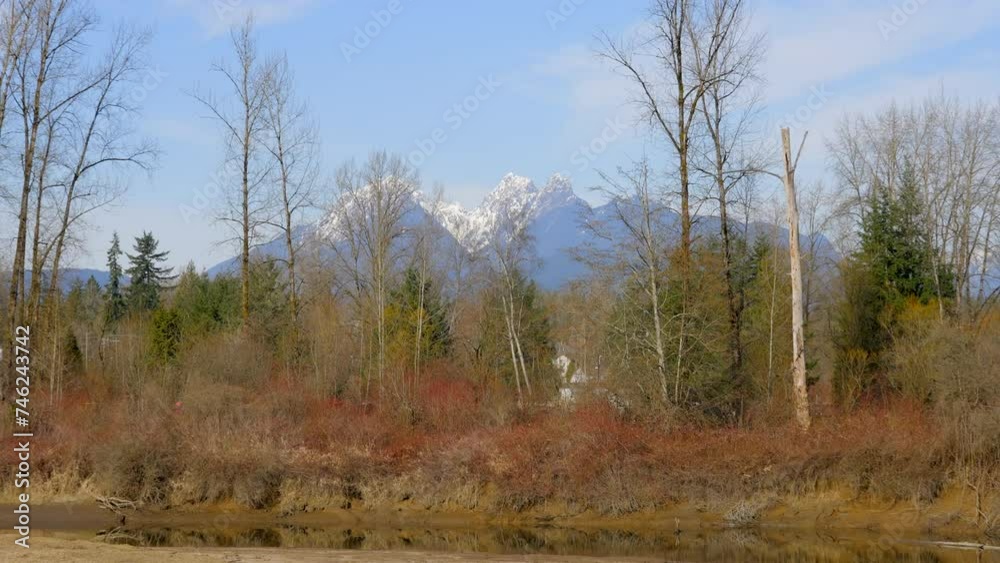 Establishing shot of majestic mountain river with mountain background in Vancouver, Canada, North America. Day time on April 2023. Still camera view. ProRes 422 HQ. Establishing shot of majestic mountain river with mountain background in Vancouver, Canada, North America. Day time on April 2023. Still camera view. ProRes 422 HQ.