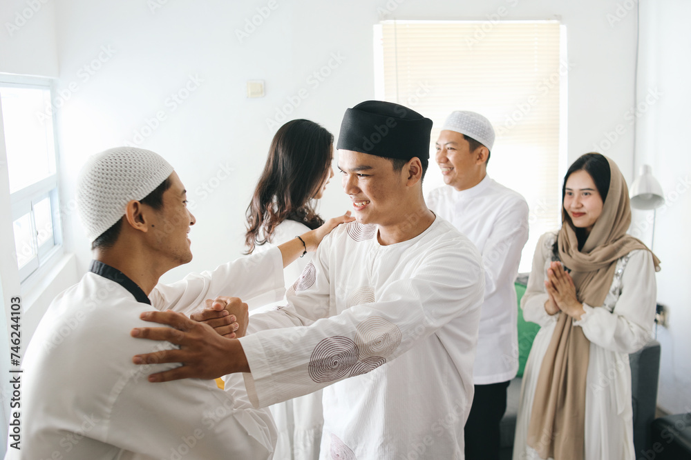 Young muslim people hand shaking to each other and asking for apologize during eid mubarak moment Young muslim people hand shaking to each other and asking for apologize during eid mubarak moment