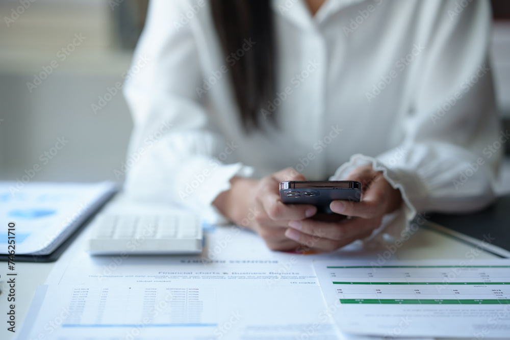 Fototapeta premium Accountant, Asian independent business woman Positive concept using smartphone to relax with mobile app and use chat business communication Contact online marketing that is extremely profitable.