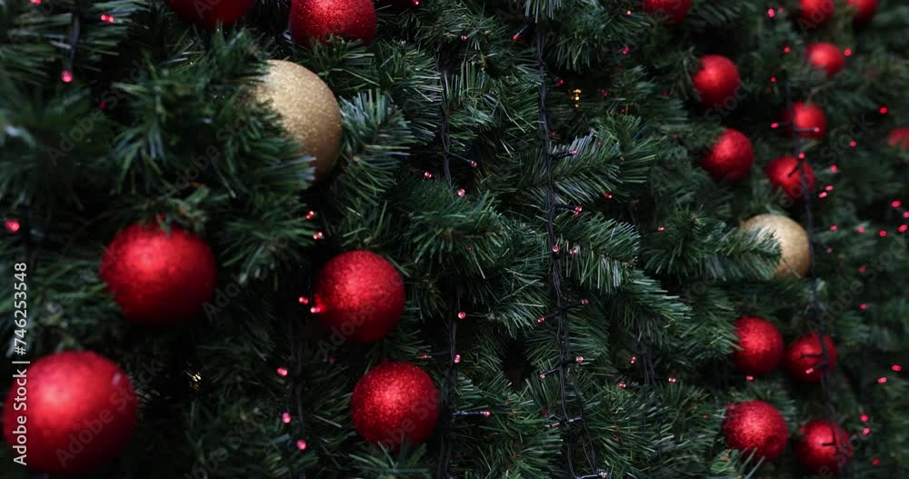 Closeup of festively decorated outdoor Christmas tree with bright red balls Closeup of festively decorated outdoor Christmas tree with bright red balls